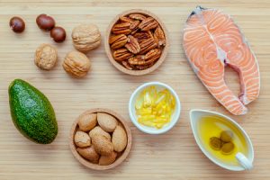 59039288 - selection food sources of omega 3 and unsaturated fats. super food high omega 3 and unsaturated fats for healthy food. almond ,pecan ,hazelnuts,walnuts ,olive oil ,fish oil ,salmon and avocado on wooden background .